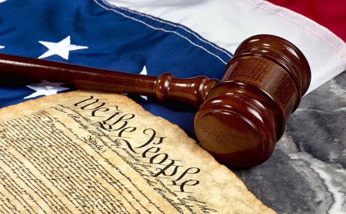 Gavel and Constitution on American flag background.