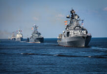 Several naval warships sailing in the ocean.