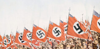 Nazi soldiers marching with swastika flags, World War II.