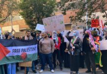 Protesters gather holding "Free Palestine" signs and banners.