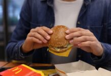 Person holding a McDonald's burger in their hands.