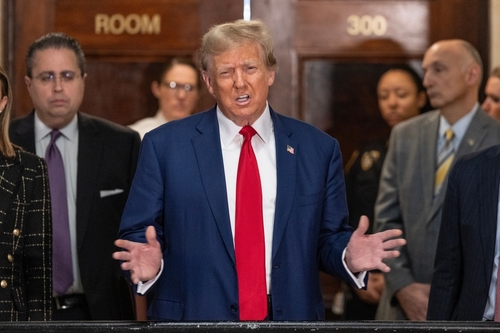 Donald Trump speaking with people in background.