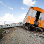Derailed train leaning off the track.