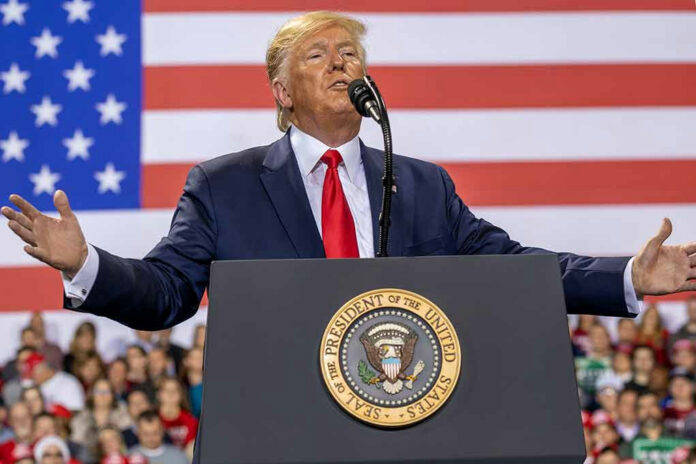 1677446302 Person speaking at a podium with American flag backdrop.