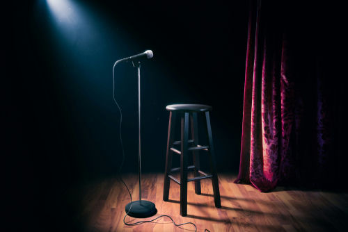 shutterstock_1031487514 Empty stage with microphone and stool under spotlight.
