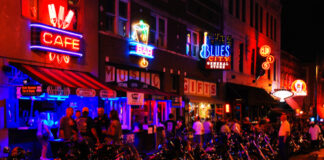 Vibrant street scene at night with neon signs and parked motorcycles