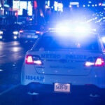 Police car with lights on in city at night.