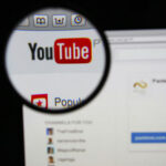 Close-up view of the YouTube website interface through a magnifying glass