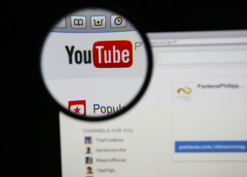 shutterstock_171257810.jpg Close-up view of the YouTube website interface through a magnifying glass