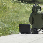 Bomb squad personnel in protective gear working on device.