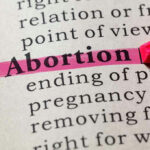 Unknown ABORTION GIANT Larger Than Planned Parenthood Highlighting the word Abortion in a dictionary.
