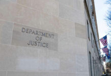 Department of Justice building with American flags outside.