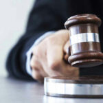 Judges hand hitting gavel on block.