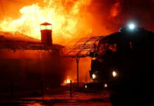 Fires ENGULF Ancient Town — Why is This Kept QUIET? Building on fire with a firetruck in foreground.