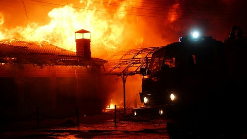 shutterstock2148932469-1jpg Building on fire with a firetruck in foreground.