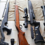 Gun BAN BACKFIRES — Prosecutors REFUSE Assorted rifles and shotguns laid out on a table