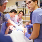 Medical team working on patient in hospital emergency room.