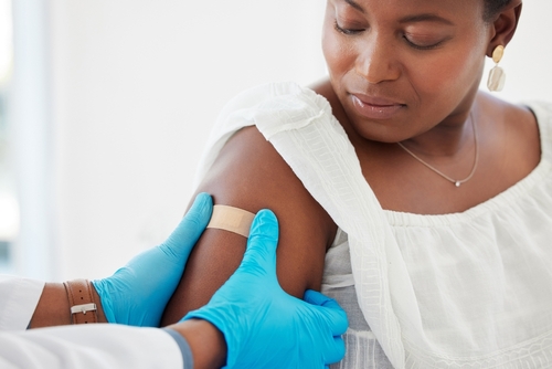 Healthcare,,Plaster,And,Doctor,Helping,A,Patient,After,An,Injection A healthcare professional administering a vaccine to a patient