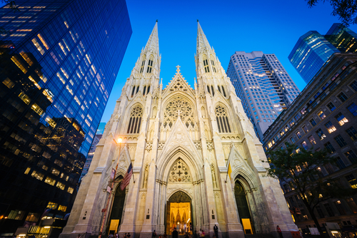 St.,Patrick's,Cathedral,At,Night,,In,Manhattan,,New,York. Gothic cathedral illuminated at dusk surrounded by modern skyscrapers