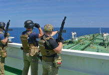 Gripping Raid, Missing Proof—Who Authorized This? Armed security team on a ship deck overlooking a large tanker at sea
