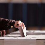 Ballots After Tuesday — Court Lights the Fuse Person placing a ballot into a voting box