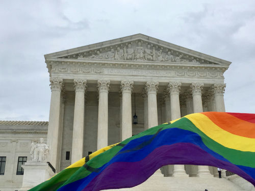 shutterstock_1526443655 Supreme Court building with rainbow flag in foreground.