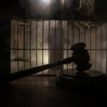 Jury Heat Rising—YouTube Ducks Spotlight A gavel placed on a wooden surface in front of a barred cage with a smoky background