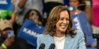 Smiling woman speaking at a crowded event indoors