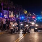 Shell Casings Blanket Downtown—Where’s The Suspect? Police officers managing a crowd on a busy street at night