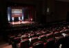 Audience in a theater watching a stage presentation