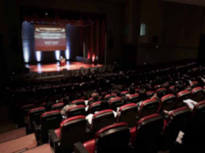 shutterstock_559521175 Audience in a theater watching a stage presentation